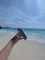Person holding a flow recovery bar on a beach with ocean and sky in the background